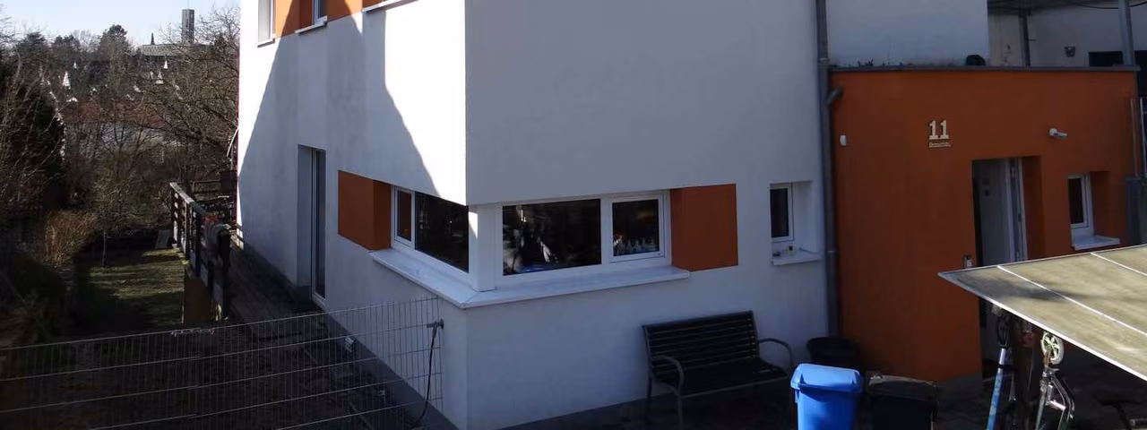 Zwangsversteigerung Einfamilienhaus in Schweinfurt, Eselshöhe – Süd-West-Ansicht der Gartenseite mit Hangunterkellerung, Balkon und Terrasse.
