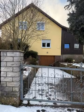 Zwangsversteigerung Zweifamilienhaus in Wenzenbach – Nordansicht des Wohnhauses mit Zufahrt und integriertem Garagentor.