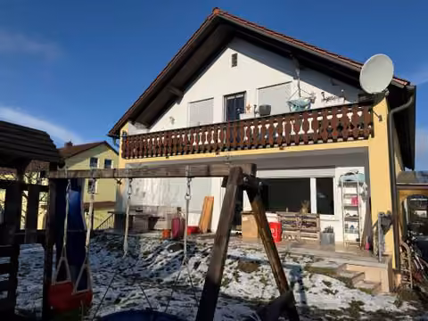 Zwangsversteigerung Zweifamilienhaus in Wenzenbach – Südansicht des Wohnhauses mit Balkon und Gartenbereich.