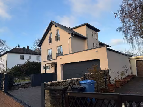 Zwangsversteigerung Einfamilienhaus in Kelkheim, Kelkheim-Mitte – Vorderansicht des Einfamilienhauses mit Doppelgarage und Zufahrt.
