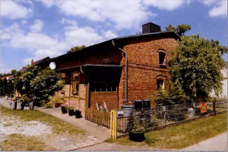 Zwangsversteigerung Mehrfamilienhaus in Wilhelmsburg, Eichhof – Schrägansicht des Wohnhauses mit Giebelseite und Vorgartenbereich.