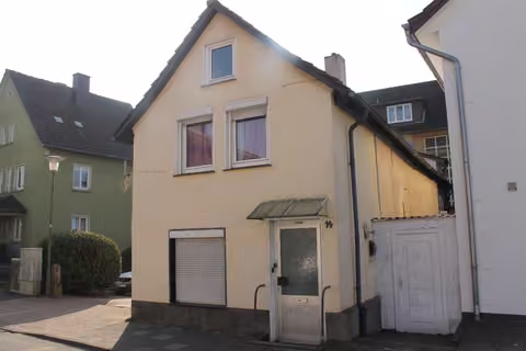 Zwangsversteigerung Einfamilienhaus in Bad Pyrmont, Oesdorf – Nordwestliche Außenansicht des zweigeschossigen Einfamilienhauses mit Hauseingang.