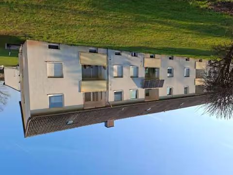 Zwangsversteigerung Eigentumswohnung in Hameln, Hastenbeck – Südansicht des Wohnblocks mit Balkonen und Fenstern der Eigentumswohnung.