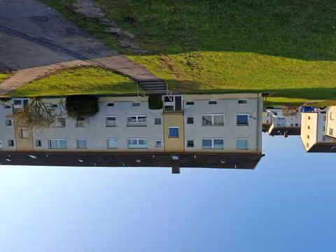 Zwangsversteigerung Eigentumswohnung in Hameln, Hastenbeck – Nordansicht des Wohnblocks Teichstraße 16 mit Hauseingang und Zuwegung.