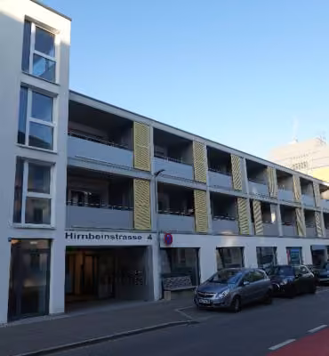 Zwangsversteigerung Eigentumswohnung in Kempten – Außenansicht der Wohnanlage Hirnbeinstraße 4 mit Pfeilmarkierung der Wohnung.