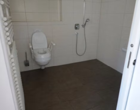 Zwangsversteigerung Eigentumswohnung in Kempten – Barrierefreies Badezimmer mit bodengleicher Dusche und Wand-WC.
