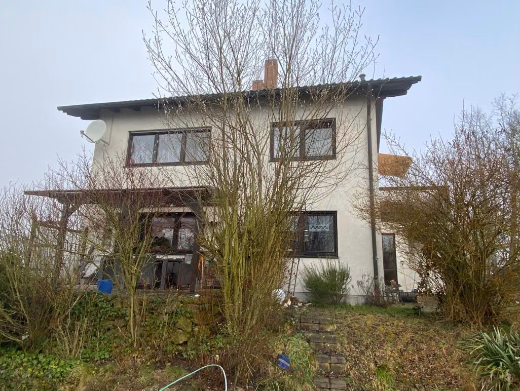 Zwangsversteigerung Mehrfamilienhaus in Breitengüßbach – Süd- und Gartenansicht des Wohnhauses mit Terrasse und Balkon.