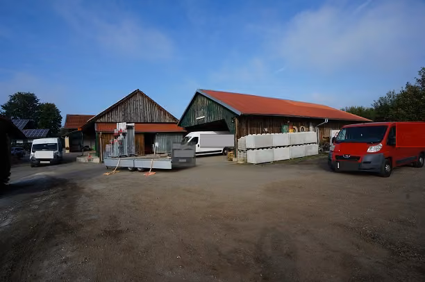 Zwangsversteigerung Grundstück in Windorf, Hitzing – Ostansicht der Lagerhalle und des Aufenthaltsraums mit Hofgelände.