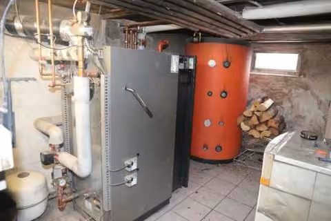 Zwangsversteigerung Mehrfamilienhaus in Kümmersbruck – Moderne Holzzentralheizung mit großem Warmwasserspeicher im Keller.