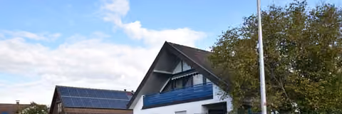Zwangsversteigerung Einfamilienhaus in Baiersdorf, Wellerstadt – Straßenansicht des freistehenden Einfamilienhauses mit Sichtschutzzaun.