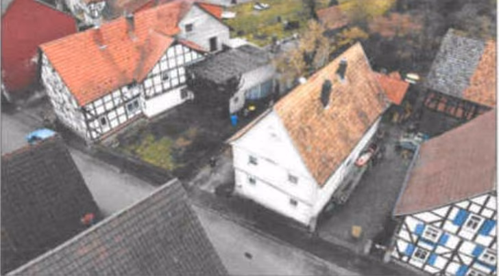 Zwangsversteigerung Zweifamilienhaus in Eschwege, Albungen – Luftaufnahme der straßenseitigen Ostansicht des Wohnhauses und der Nebengebäude.