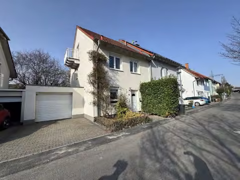 Zwangsversteigerung Doppelhaushälfte in Maintal, Bischofsheim – Straßenansicht der Doppelhaushälfte mit Hauseingang und Garage.