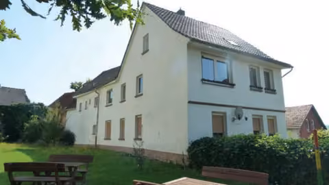 Zwangsversteigerung Einfamilienhaus in Alheim, Heinebach – Seitenansicht des Wohnhauses mit Vorgartenbereich.