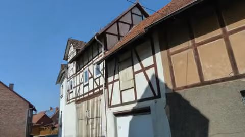 Zwangsversteigerung Einfamilienhaus in Alheim, Heinebach – Fachwerk- und Fassadendetail der angebauten Scheune mit Toren.