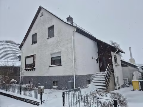 Zwangsversteigerung Einfamilienhaus in Bad Endbach, Bottenhorn – Vorderansicht des Wohnhauses mit Eingangstreppe im Winter.
