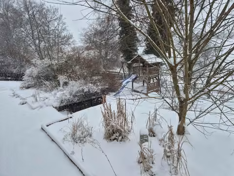 Zwangsversteigerung Einfamilienhaus in Bad Endbach, Bottenhorn – Blick in den verschneiten Garten mit Kinderspielgerät.