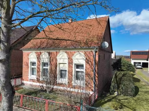 Zwangsversteigerung Einfamilienhaus in Meiersberg – Außenansicht der Straßen- und Giebelfassade des Wohnhauses mit Hofeinfahrt.