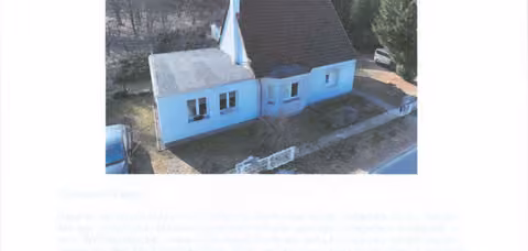 Zwangsversteigerung Einfamilienhaus in Blankensee – Straßen- und Frontansicht des Einfamilienhauses mit Anbau und blau eingefassten Fenstern.