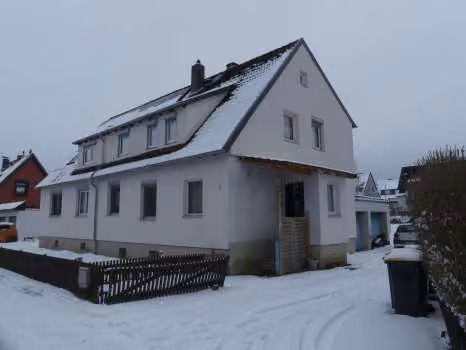 Zwangsversteigerung Zweifamilienhaus in Sehlde – Straßenansicht des Zweifamilienhauses im Winterzustand.