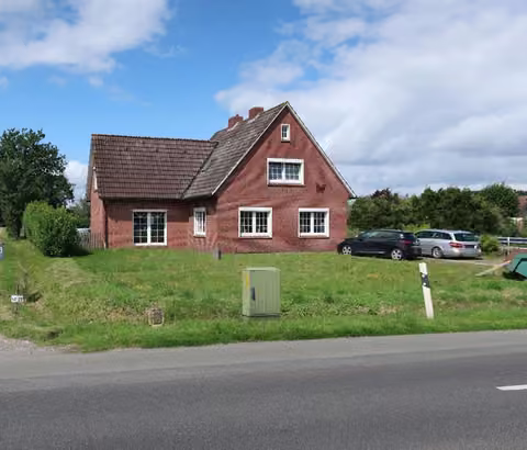Zwangsversteigerung Einfamilienhaus in Weener, Holthusen – Vorderansicht des freistehenden Einfamilienhauses von der Tichelwarfer Straße.