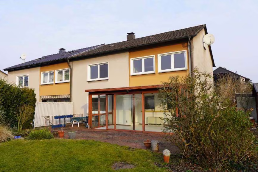 Zwangsversteigerung Doppelhaushälfte in Kamen, Methler – Südansicht der Doppelhaushälfte mit Wintergarten und Gartenbereich.