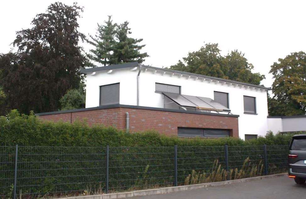 Zwangsversteigerung Einfamilienhaus in Hilden – Straßenansicht des Gebäudes mit Staffelgeschoss und Solaranlage.