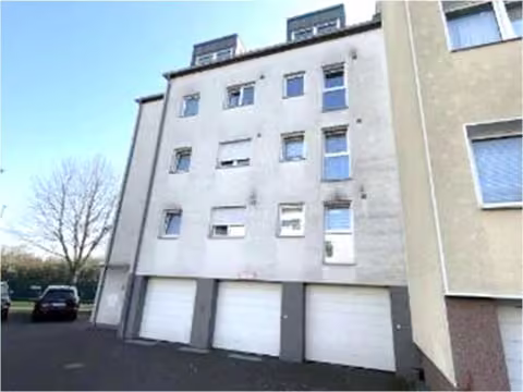 Zwangsversteigerung Mehrfamilienhaus in Köln, Bilderstöckchen – Vorderansicht des Neubau-Mehrfamilienreihenendhauses Mülhauser Straße 4 a mit Garageneinfahrten.