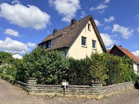 Zwangsversteigerung Zweifamilienhaus in Bad Oeynhausen, Eidinghausen – Seitenansicht des Wohnhauses mit Einfahrt und Garagenbereich.