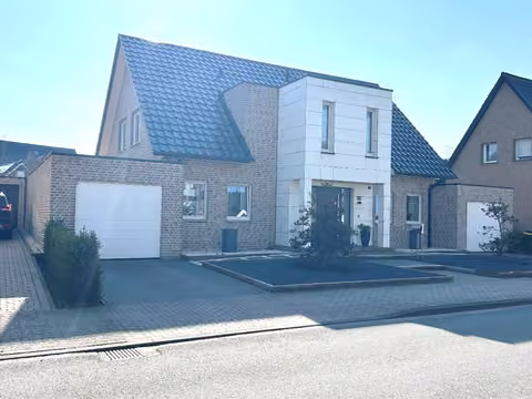 Zwangsversteigerung Einfamilienhaus in Ochtrup – Frontale Außenansicht des freistehenden Einfamilienhauses von Nordwesten mit Garage und Vorgarten.