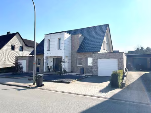 Zwangsversteigerung Einfamilienhaus in Ochtrup – Außenansicht des Wohnhauses von Nordosten mit zweiter Garage und Zufahrt.