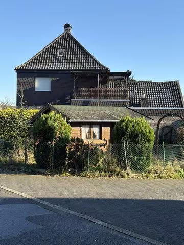 Zwangsversteigerung Einfamilienhaus in Isselburg – Straßenansicht Einmündungsbereich mit Wohnhaus und Anbau.