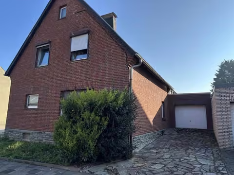 Zwangsversteigerung Einfamilienhaus in Titz, Rödingen – Straßenansicht des freistehenden Einfamilienhauses mit Vorgarten und Garagenzufahrt.