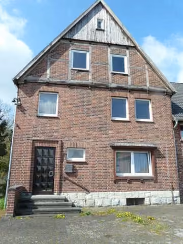 Zwangsversteigerung Zweifamilienhaus in Soest, Katrop – Eingangsfassade des Einfamilienhauses mit Treppenaufgang von Nordosten.