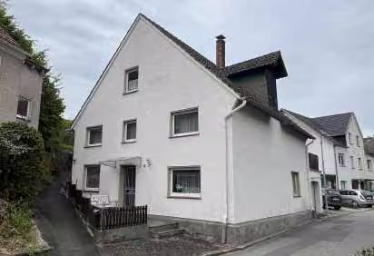 Zwangsversteigerung Doppelhaushälfte in Beverungen, Dalhausen – Südliche Giebelseite des Wohnhauses an der ansteigenden Ringstraße.