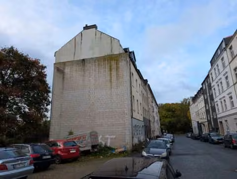 Zwangsversteigerung Mehrfamilienhaus in Dortmund, Eving – Giebelansicht von Nordosten mit angrenzender Nachbarbebauung.