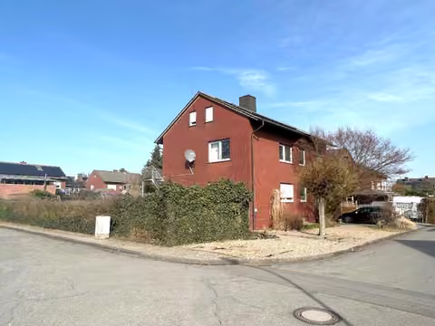 Zwangsversteigerung Zweifamilienhaus in Nordwalde – Westfassade mit Außentreppe und Balkonanbau.