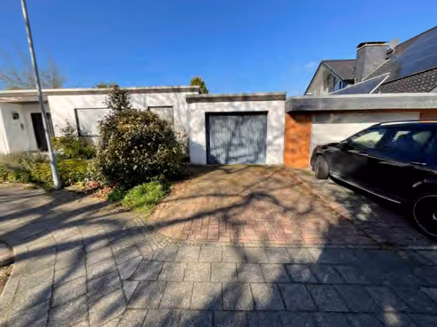 Zwangsversteigerung Einfamilienhaus in Rheurdt, Schaephuysen – Ostansicht des Wohnhauses mit Zufahrt und angebauter Garage.