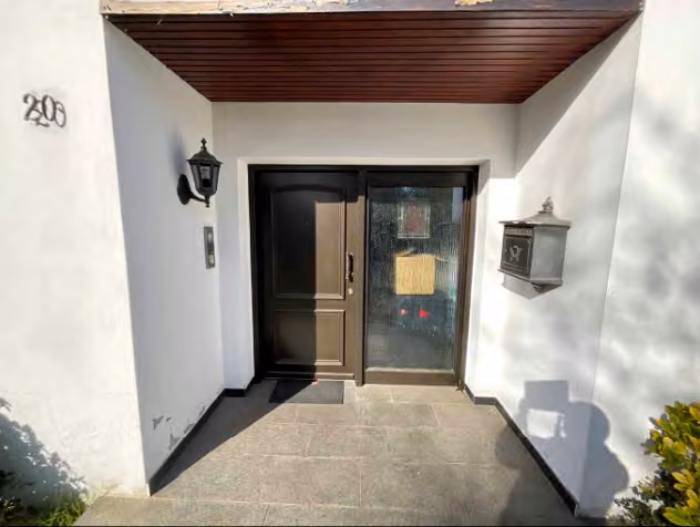 Zwangsversteigerung Einfamilienhaus in Rheurdt, Schaephuysen – Überdachter Hauseingangsbereich des Bungalows von der Straße aus gesehen.