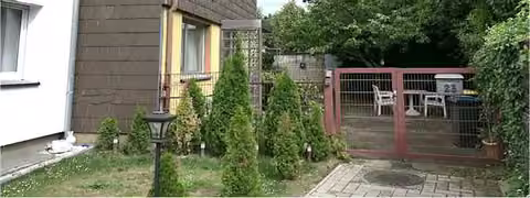 Zwangsversteigerung Zweifamilienhaus in Köln, Pesch – Ansicht des Hauseingangsbereichs mit Faserzementverkleidung im Obergeschoss.