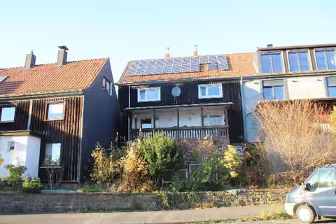 Zwangsversteigerung Doppelhaushälfte in Wuppertal, Barmen – Rückwärtige Ansicht des Gebäudes mit Balkon und Photovoltaikanlage.
