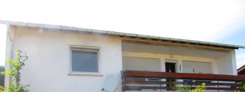 Zwangsversteigerung Einfamilienhaus in Ransbach-Baumbach, Ransbach – Vorderansicht des freistehenden Einfamilienhauses mit Balkon und Vorgarten.