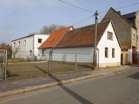 Zwangsversteigerung Einfamilienhaus in Teuchern, Nessa – Wohnhaus und Werkstattgebäude von der Straßenseite aus südwestlicher Richtung.