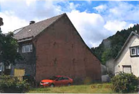 Zwangsversteigerung Zweifamilienhaus in Steinbach-Hallenberg, Altersbach – Ansicht der Giebelseite des Wohnhauses mit Sichtmauerwerk.