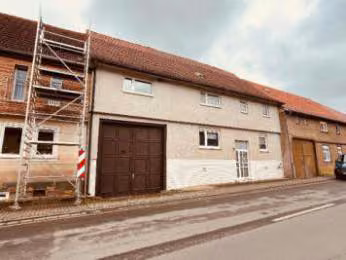 Zwangsversteigerung Zweifamilienhaus in Tüttleben – Detailansicht der Straßen- und Vorderfassade mit Eingangstür und Hoftor.