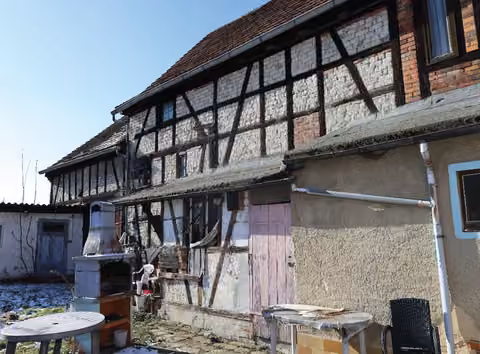 Zwangsversteigerung Einfamilienhaus in Waldeck – Nordostansicht der Scheune mit Fachwerkstrukturen und Torzufahrten.