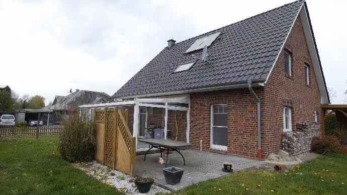 Zwangsversteigerung Einfamilienhaus in Barßel, Elisabethfehn – Südöstliche Gartenansicht des Einfamilienhauses mit Wintergartenanbau.