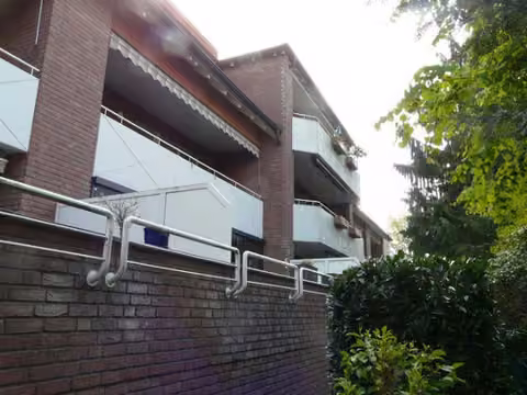 Zwangsversteigerung Eigentumswohnung in Bad Sassendorf – Rückwärtige Gebäudeansicht von Nordwesten mit Balkonen und Loggien.