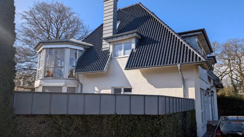 Zwangsversteigerung Eigentumswohnung in Achim, Baden – Straßenseitige Ansicht des Gebäudes mit Garageneinfahrten.