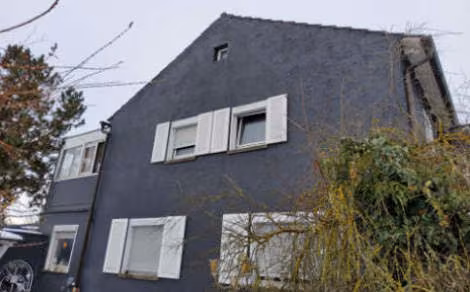 Zwangsversteigerung Doppelhaushälfte in Sennfeld – Giebelseite Ost mit rückseitigem Anbau und überdachtem Balkon.