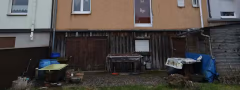 Zwangsversteigerung Reihenhaus in Teuschnitz – Ost-Ansicht der Straßenfront des Reihenmittelhauses mit Eingangsbereich.